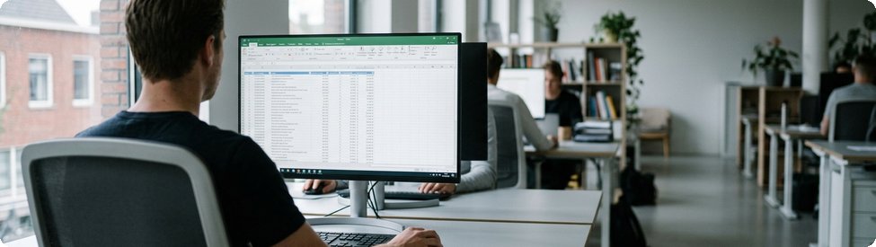 Medewerker bekijkt een overzicht van softwarefacturen op een breed beeldscherm